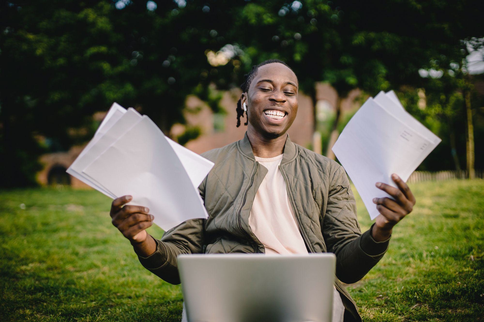 A man holds pages of interview documents, smiling