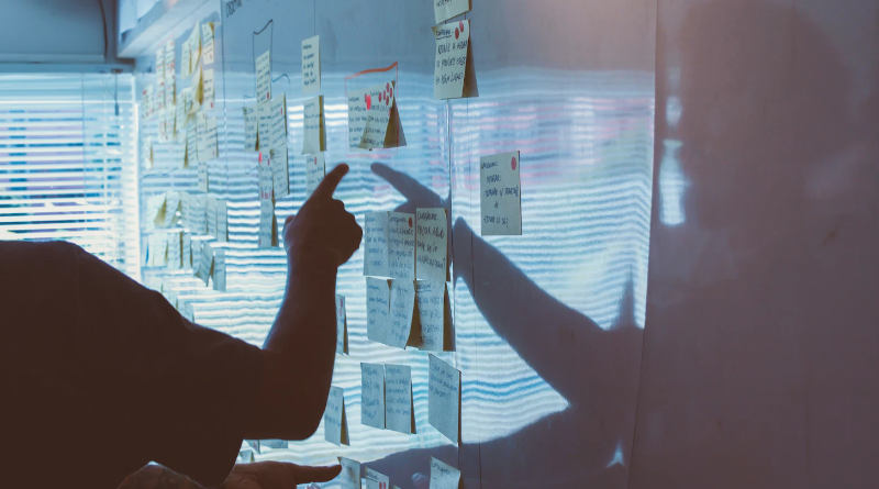 Someone pointing to memos on a whiteboard