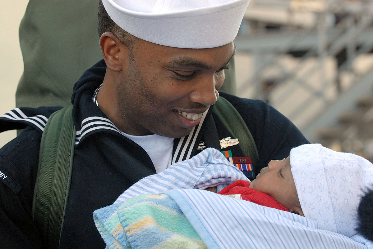 A Naval officer holding his child for the first time
